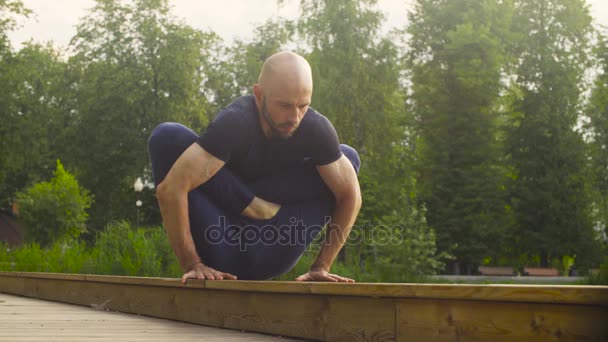 Un hombre haciendo ejercicios de yoga en el parque — Vídeo de stock