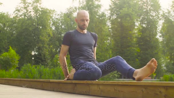 Un homme faisant des exercices de yoga dans le parc — Video