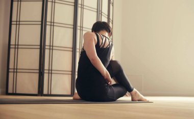 Genç bir kadın Yoga-asanas gerçekleştirme
