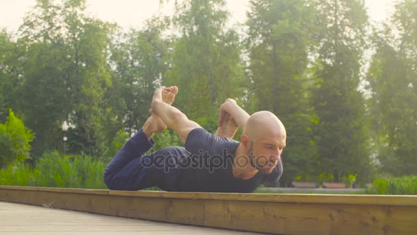 Un hombre haciendo ejercicios de yoga en el parque — Vídeos de Stock