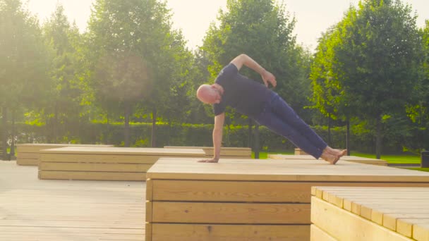 Un homme faisant des exercices de yoga dans le parc — Video