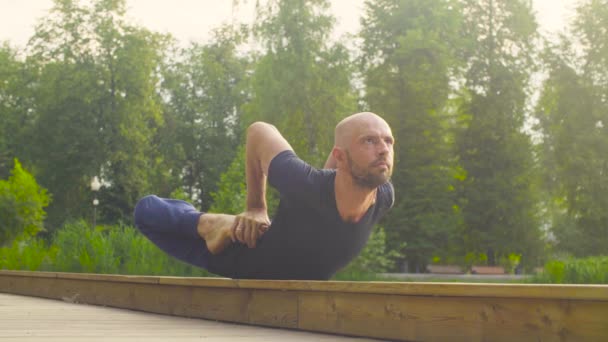 Człowiek robi ćwiczenia jogi w parku — Wideo stockowe