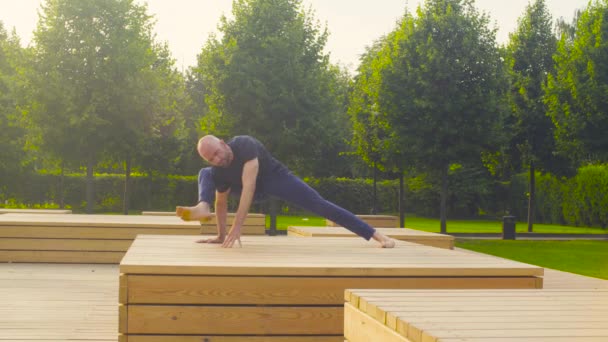 Un homme faisant des exercices de yoga dans le parc — Video
