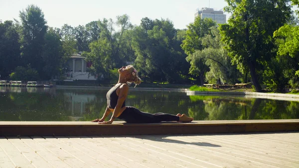 Mujer joven haciendo yoga asana - bhujangasana — Foto de Stock