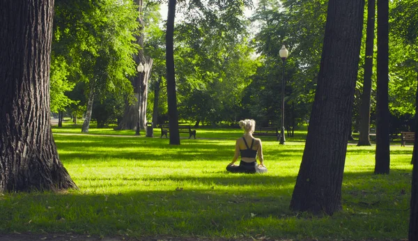 Une jeune femme assise dans une pose de lotus — Photo