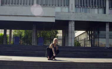 Ahşap zemine oturan genç bir kadın