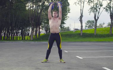 Genç bir adam dambıl kaldırıyor