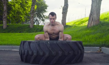 Genç kaslı adam yapıyor egzersizleri açık havada