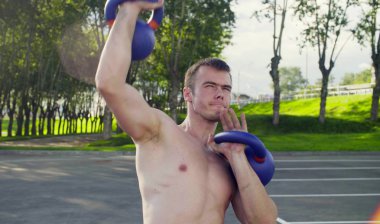 Genç bir adam dambıl kaldırıyor