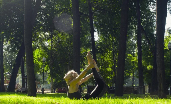 Молодая женщина, занимающаяся йогой в парке — стоковое фото