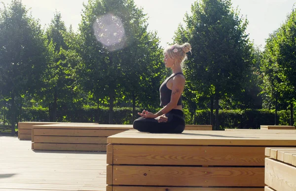 Fiatal nő meditál a parkban — Stock Fotó