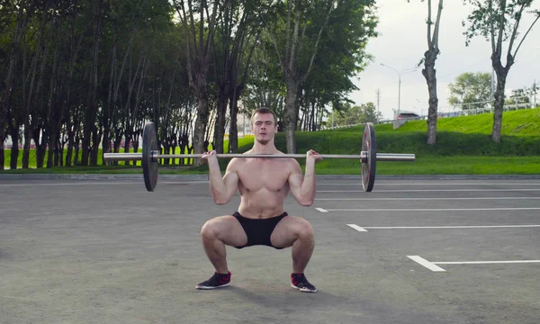 Genç bir adam halter kaldırma