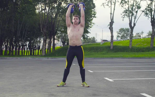 Genç bir adam dambıl kaldırıyor