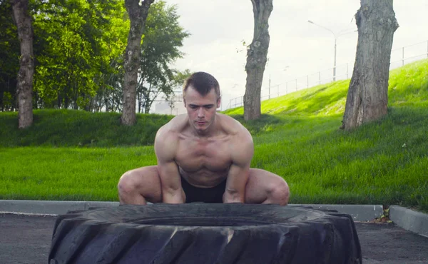 Genç kaslı adam yapıyor egzersizleri açık havada