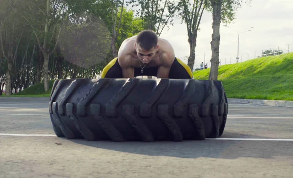 Genç kaslı adam yapıyor egzersizleri açık havada