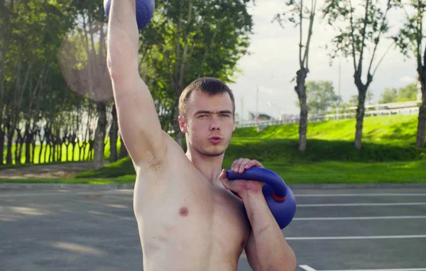 Genç bir adam dambıl kaldırıyor