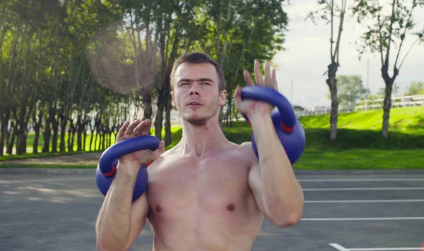 Genç bir adam dambıl kaldırıyor