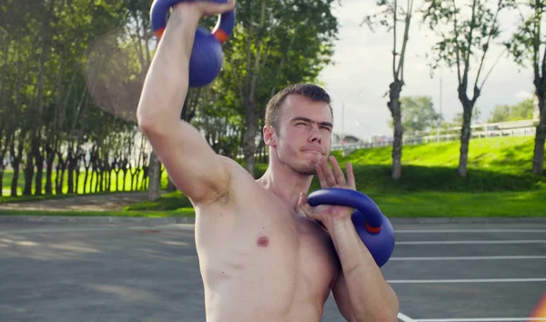 Genç bir adam dambıl kaldırıyor