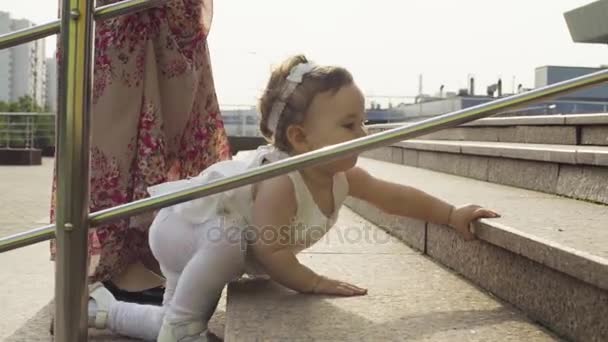 Baby flicka klättrar uppför stegen — Stockvideo