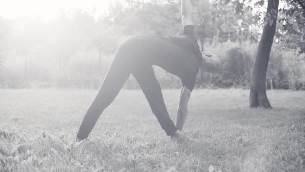 Un hombre haciendo ejercicios de yoga en el parque — Vídeo de stock