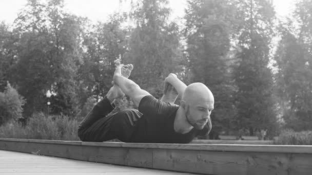 Un hombre haciendo ejercicios de yoga en el parque — Vídeo de stock