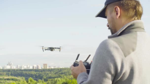 Un om care operează un quadrocopter dronă cu cameră foto — Videoclip de stoc