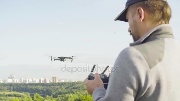 Man mengoperasikan sebuah quadrocopter drone dengan kamera — Stok Video