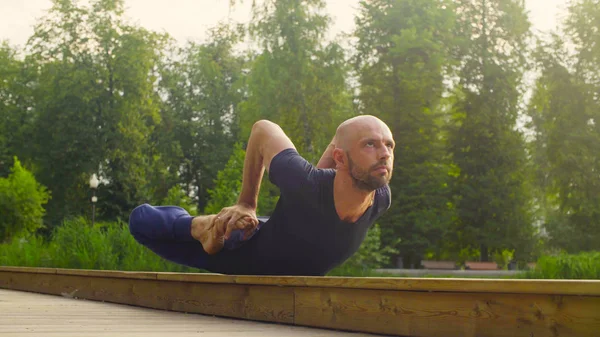 Un hombre haciendo ejercicios de yoga en el parque —  Fotos de Stock