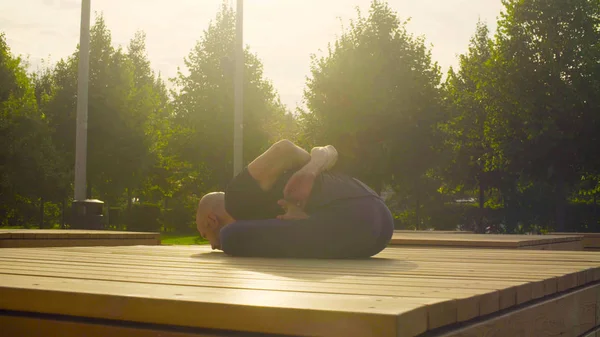 Człowiek robi ćwiczenia jogi w parku — Zdjęcie stockowe