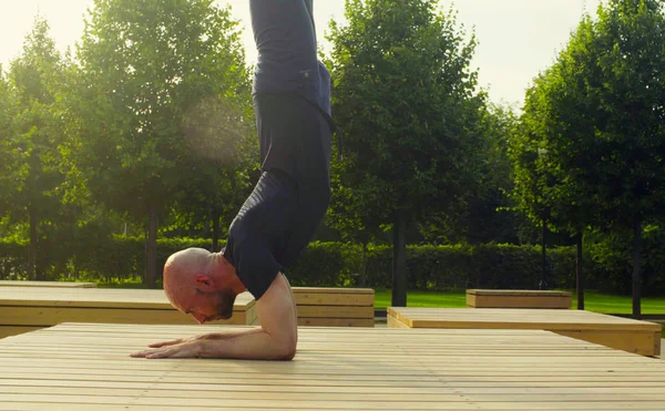 En mand laver underarmsbalance i parken - Stock-foto