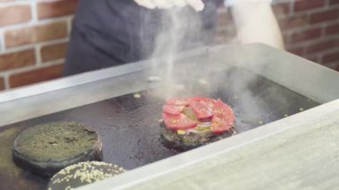 Elinde Şef domates ızgara burger koyarak