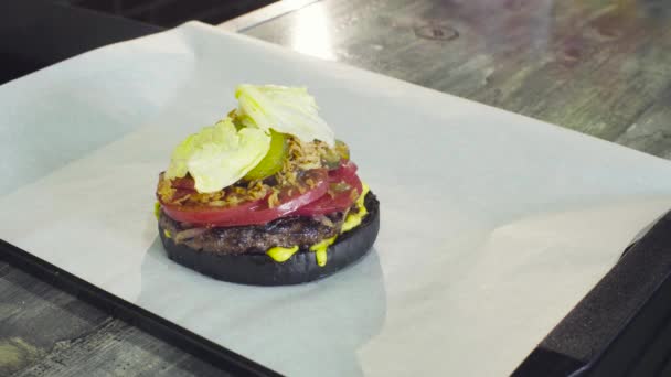 Mãos de chef pondo salada em um hambúrguer pronto — Vídeo de Stock