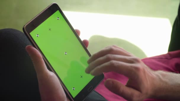Mans hand scrolling a tablet with green screen — Stock Video