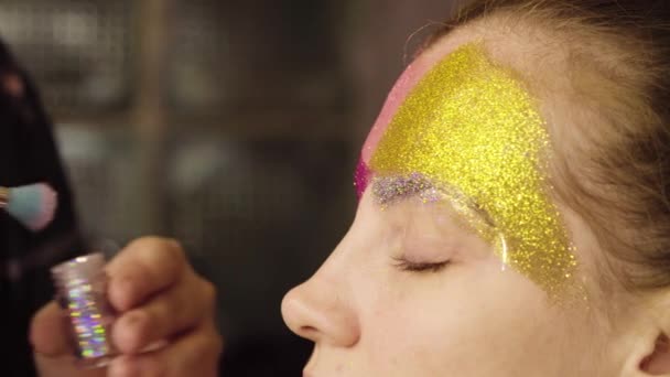 Face art. The make-up artist painting — Stock Video