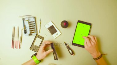 Yeşil ekran. Erkek reparing smartphone eller