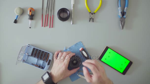 Manliga händer reparera linsen på grå bord — Stockvideo