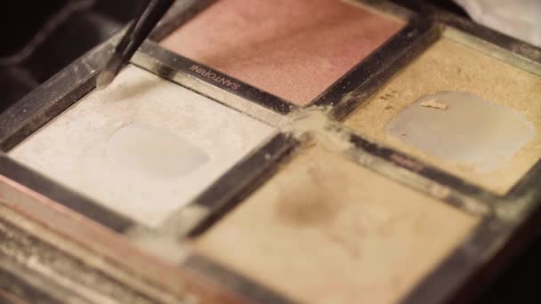 Кисть макияжа движется над тенями для век — стоковое видео