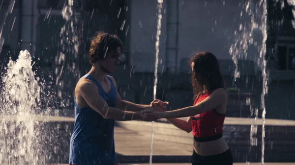 Joven pareja feliz bailando en la fuente —  Fotos de Stock