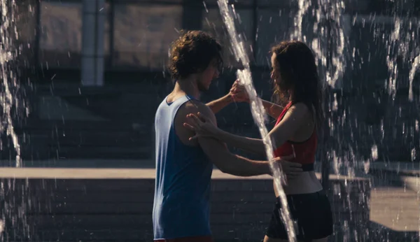 Giovane coppia felice che balla nella fontana — Foto Stock