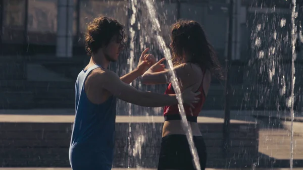 Joven pareja feliz bailando en la fuente —  Fotos de Stock