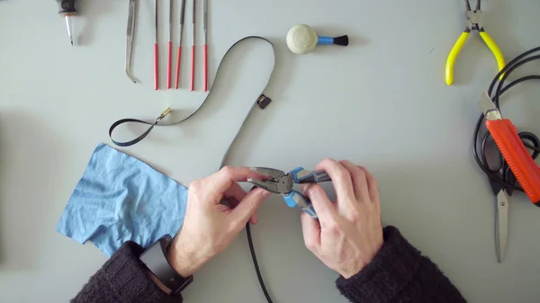 Las manos con un cuchillo y alicates reparan el cable —  Fotos de Stock