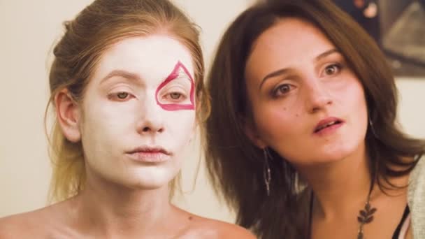 Maquillaje artista dibujar líneas rojas en la cara — Vídeo de stock