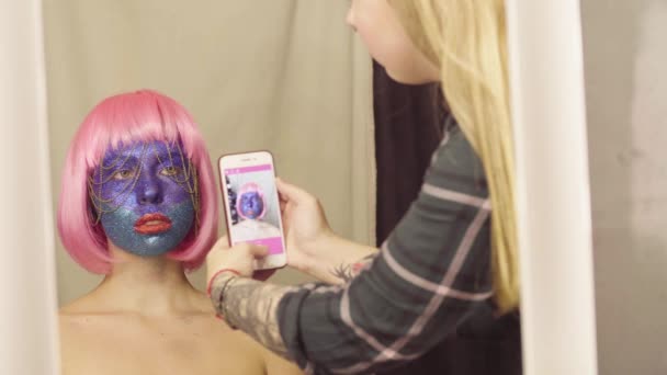O artista de maquilagem atirando no rosto do modelo — Vídeo de Stock