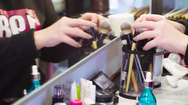 Hands of make-up artist choosing brushes — Stock Video