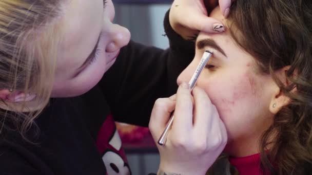 Художник макияжа наносит белые тени для век — стоковое видео