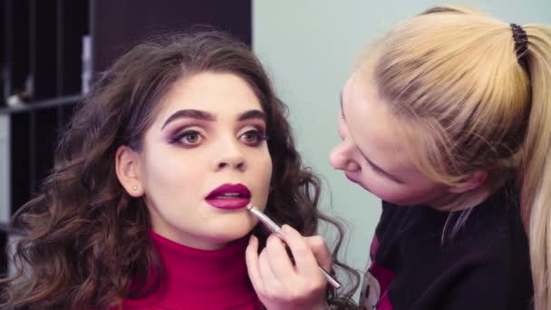 Maquillaje artista aplicando brillo de labios rosa en los labios — Vídeos de Stock