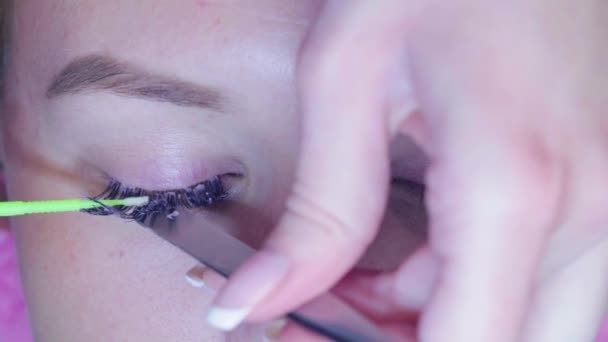 Master in de beauty salon verwijdert de oude wimpers — Stockvideo