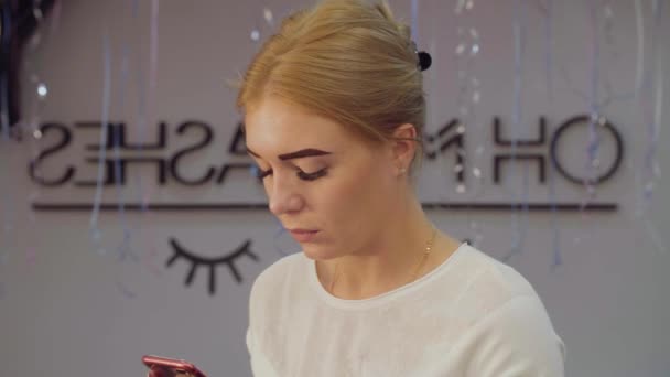 Young woman in beauty salon with smartphone — Stock Video