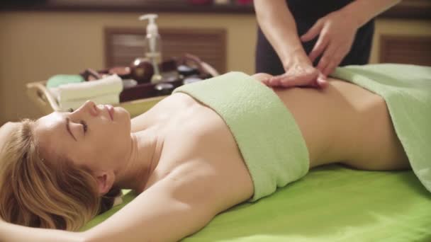 Массажист делает массаж брюшной полости женщин — стоковое видео