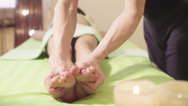Terapeuta de massagem que faz a massagem de um pé de mulher — Vídeo de Stock